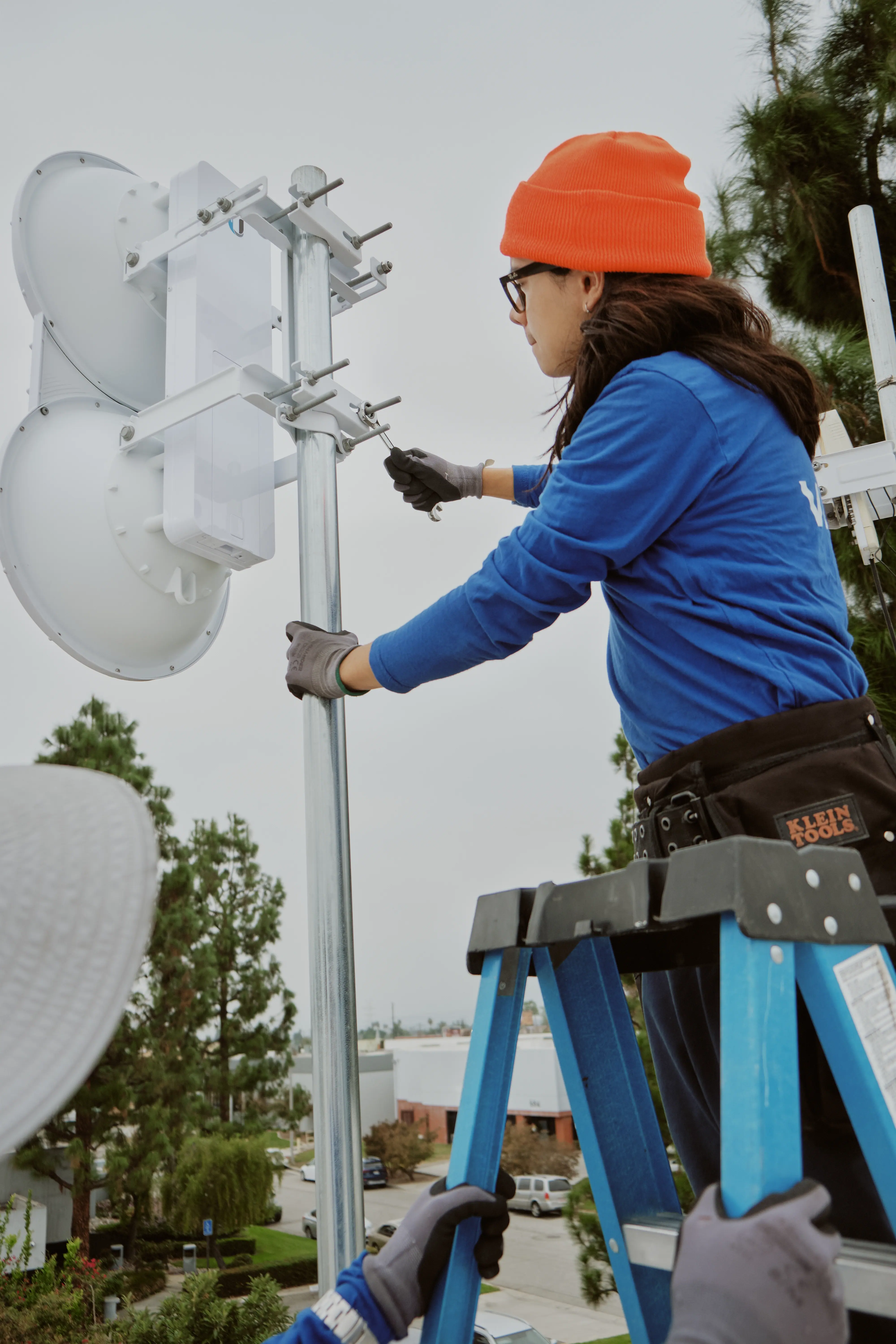 AllTime Systems technician mounting a Ubiquiti airFiber AF-5U radio to a galvanized rooftop mast