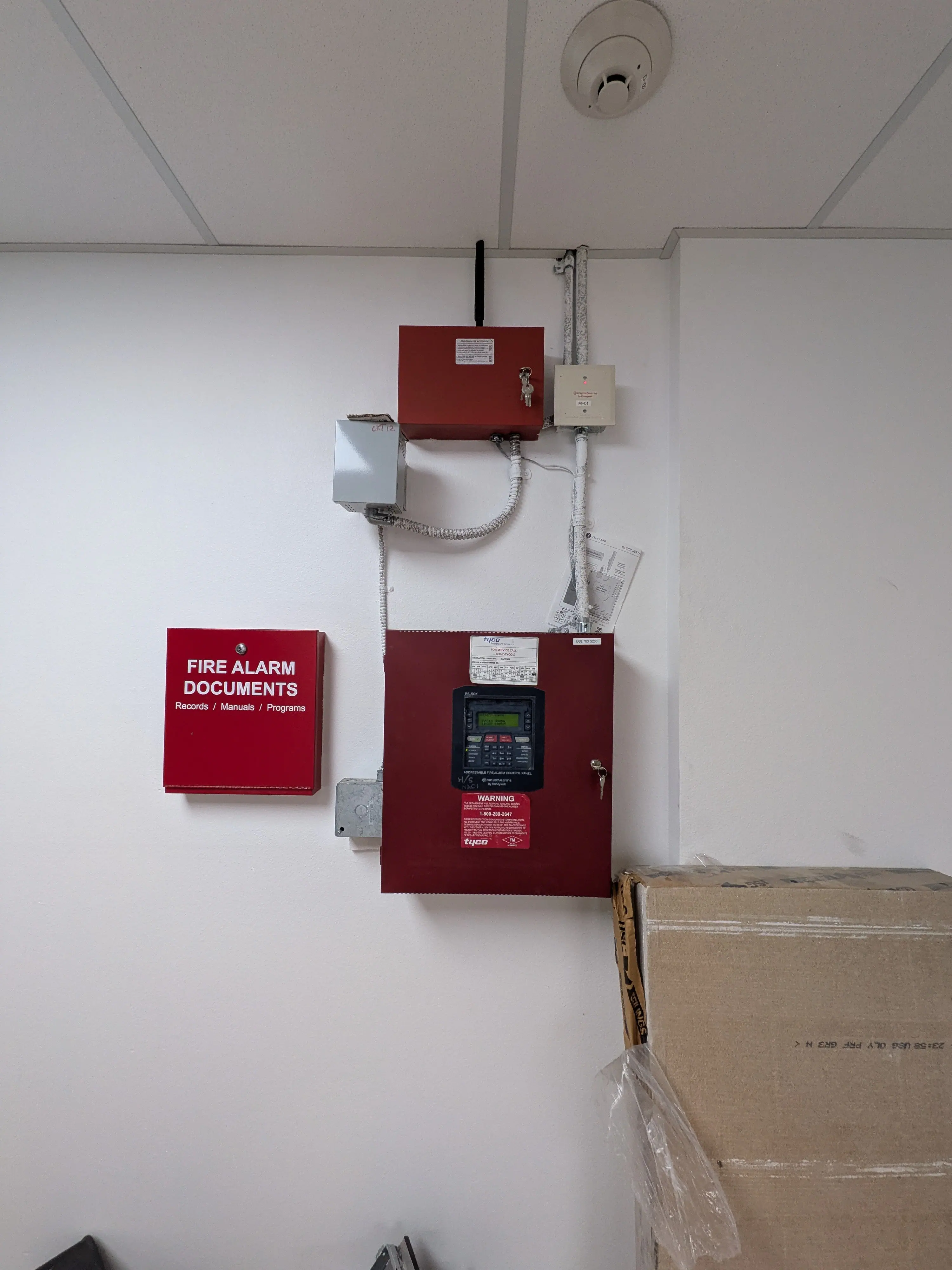 Cellular fire alarm communicator installed above a fire alarm control panel